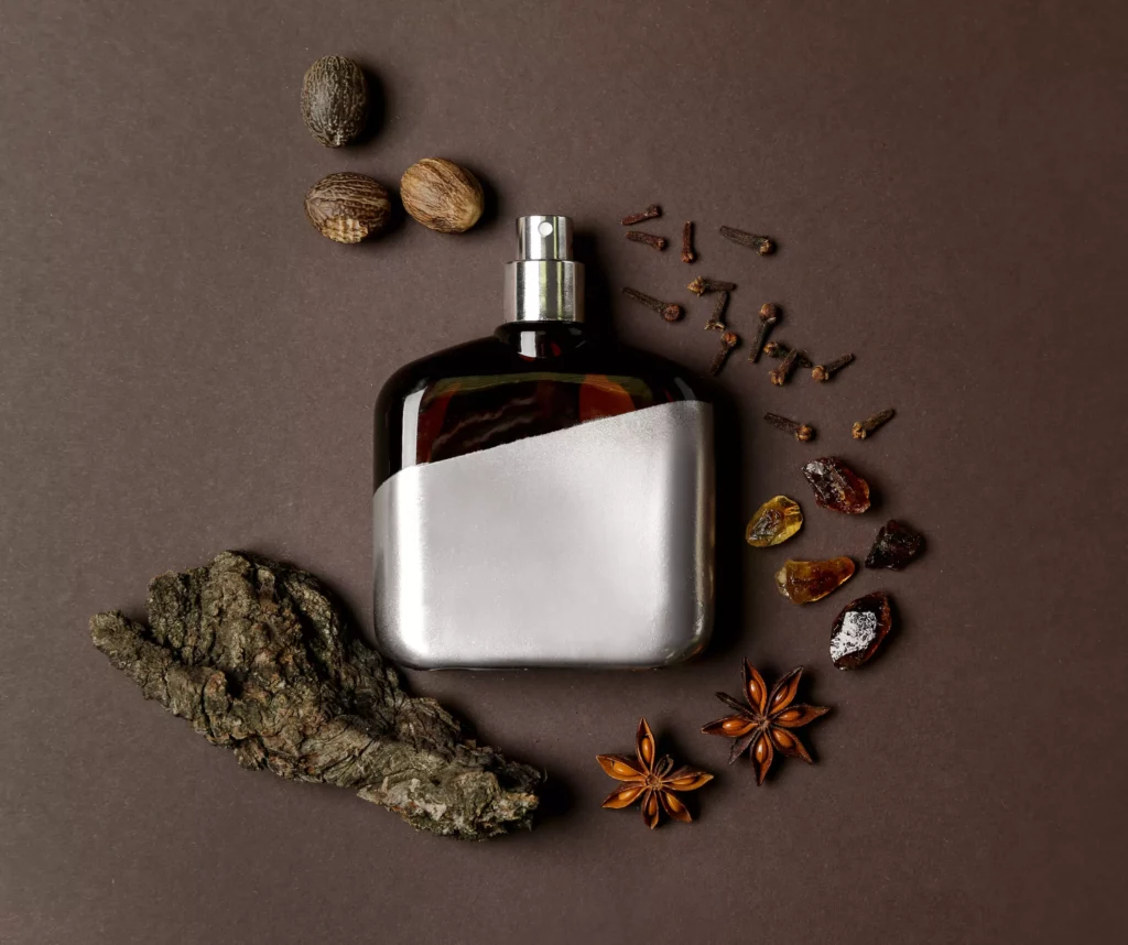 בקבוק בושם לצד מרכיבי בושם ניחוחות