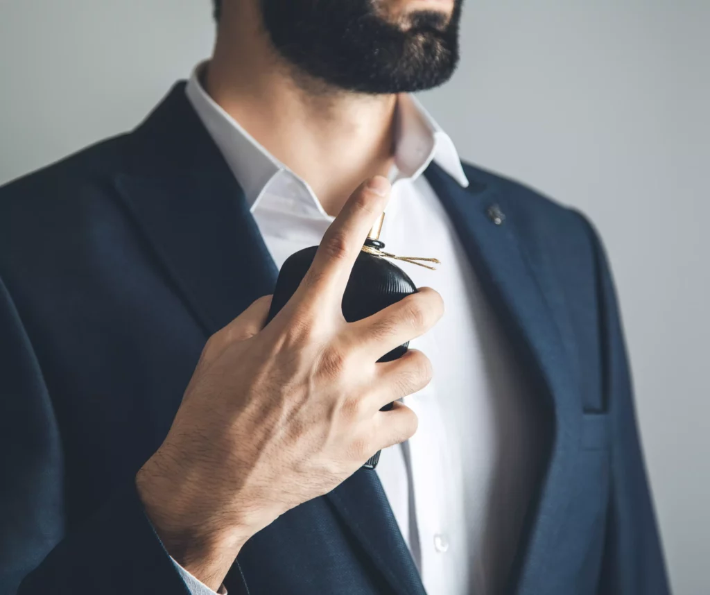 גבר בחליפה מתיז בושם